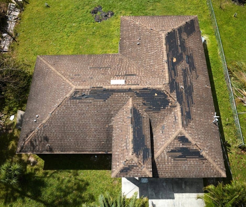 Aerial view of a storm-damaged Florida home roof with missing shingles, showing the need for a roof inspection for insurance